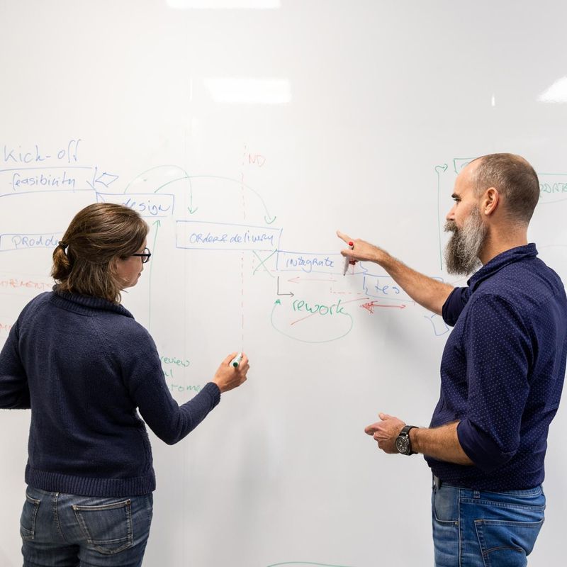 colleagues working on whiteboard during meeting